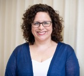 Photo of head and shoulders of Elizabeth Baldes wearing a white blouse and blue sweater.